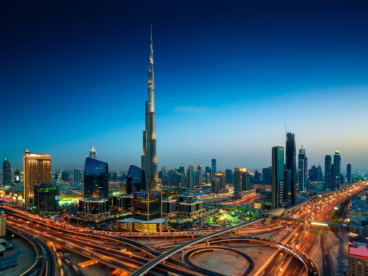 A sweeping aerial view capturing the iconic Burj Khalifa alongside Dubai’s modern urban landscape and road network.
